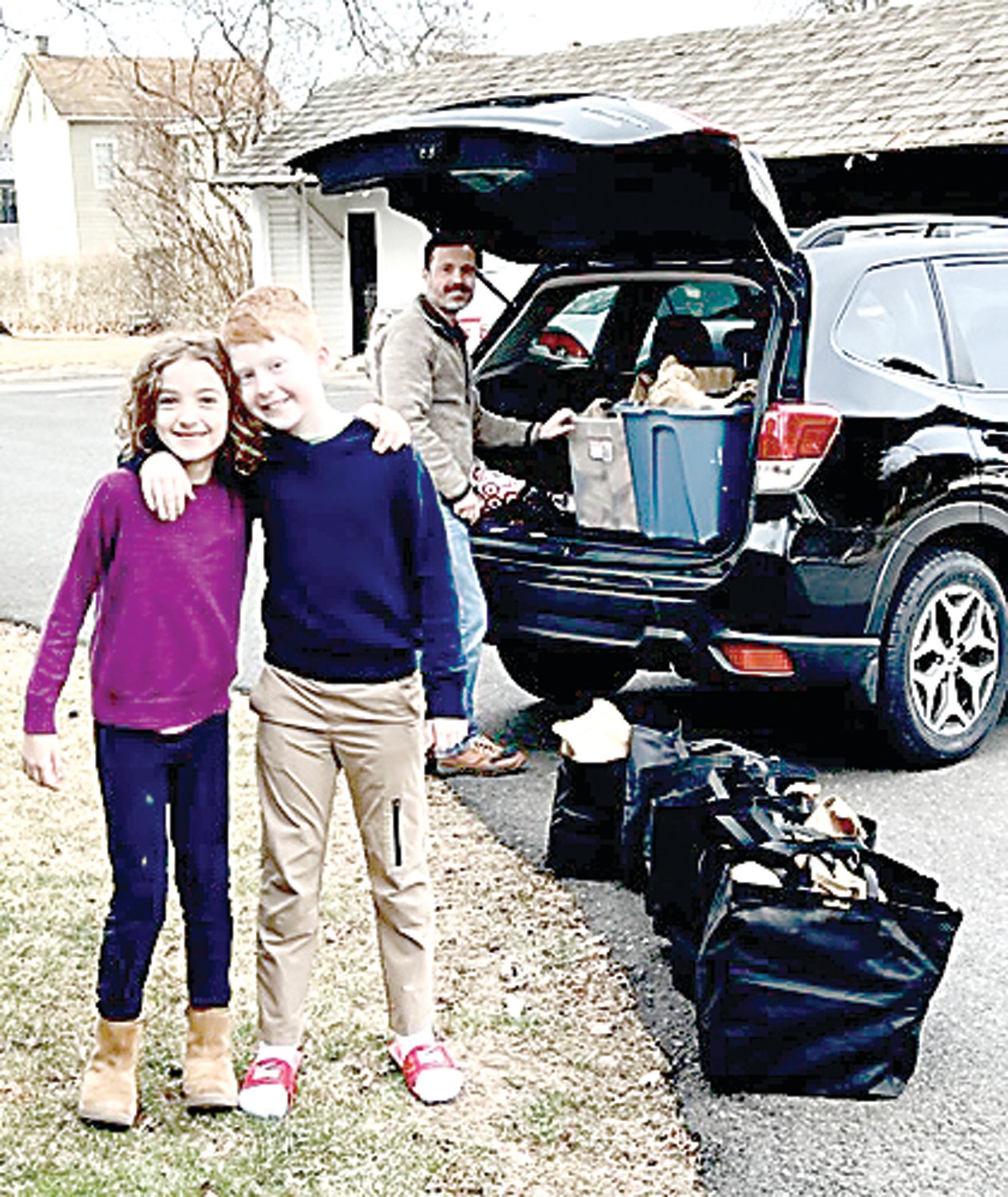 Lydia, Jack and Gene Ciccimaro pack food bags into their car.