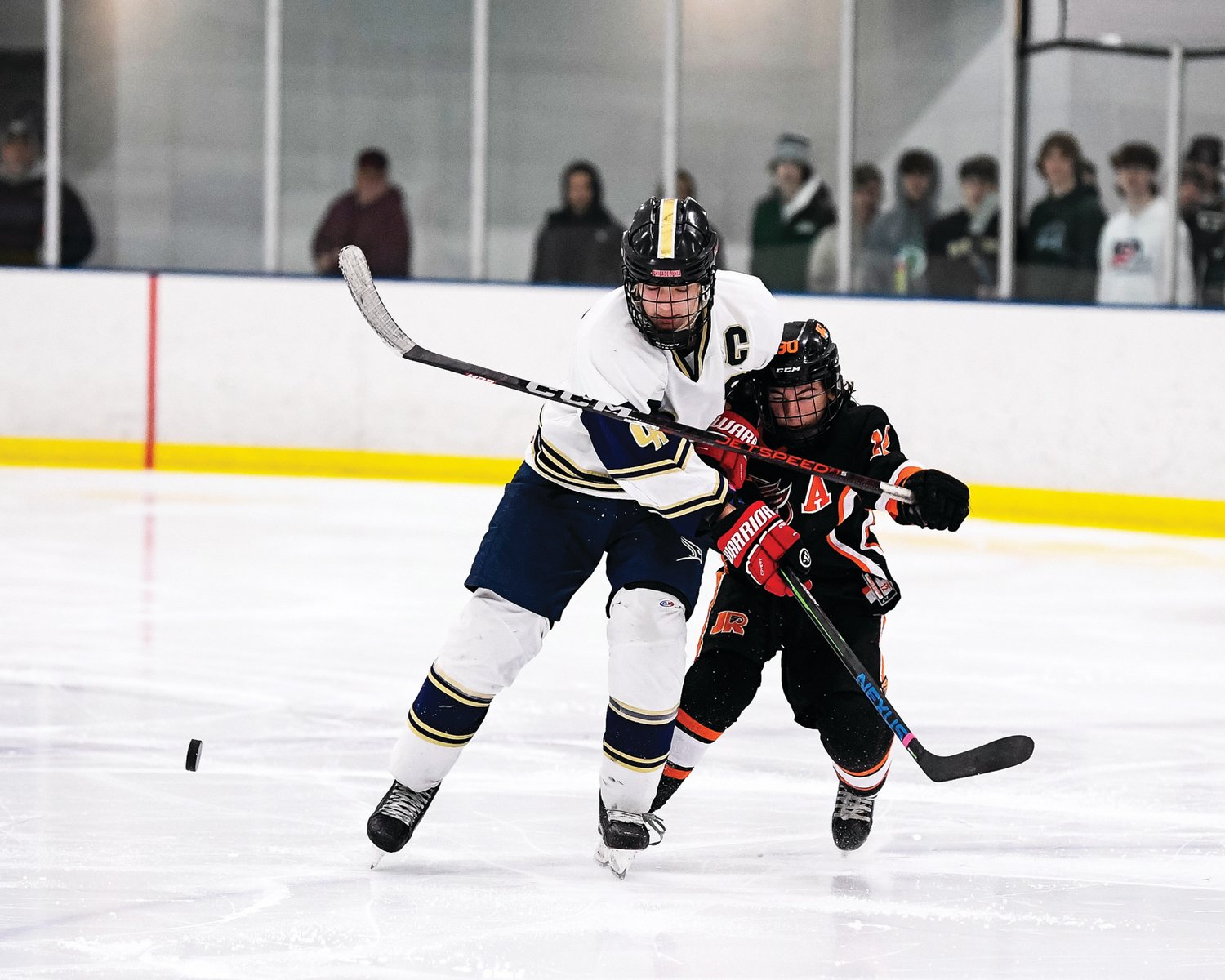 CR South’s Kevin Koles skates past Chris Sarver for the loose puck at center ice.