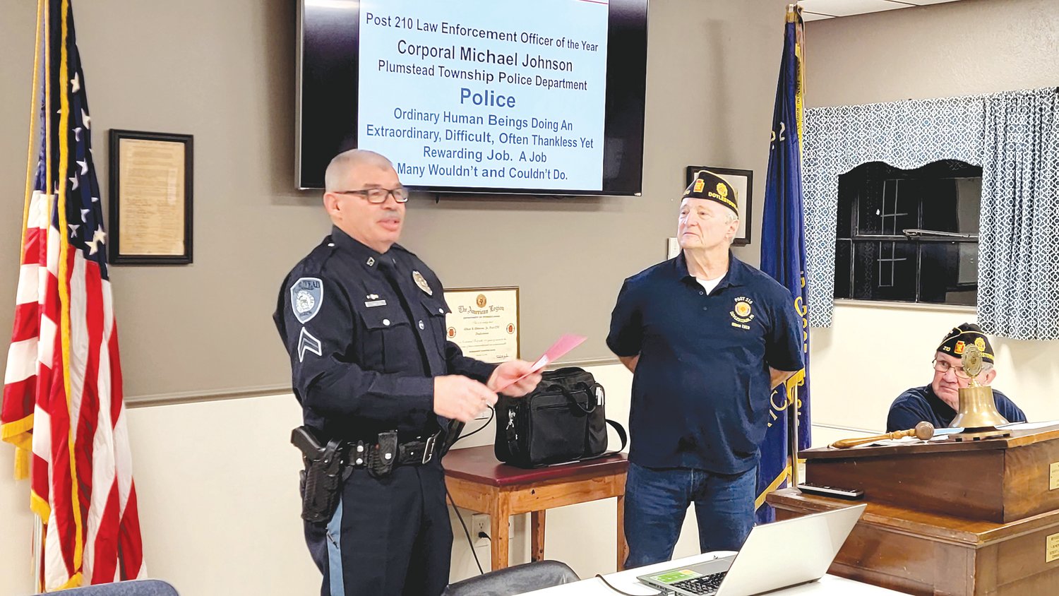 Cpl. Michael Johnson of the Plumstead Township Police Department, left, is presented with the award for Law Enforcement Officer of the Year by Pete Scott, commander of the Albert R. Atkinson Jr. Post 210 American Legion in Doylestown. Looking on is Ed Lisowski.