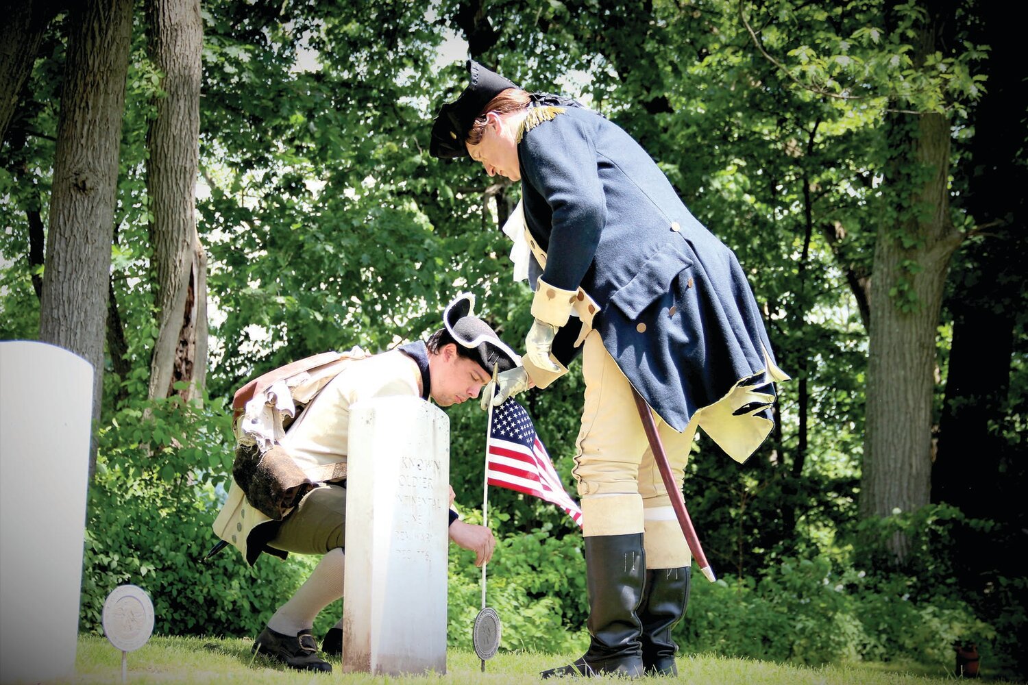 Gen. George Washington, portrayed by John Godzieba, right, helps place a flag at a gravesite  near the Thompson-Neely House in Washington Crossing.
