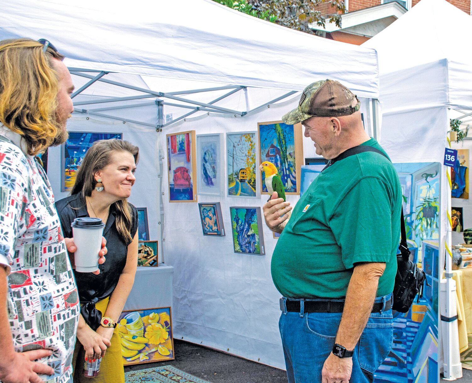 A festival goer and his pet parrot check out various vendors at the Doylestown Arts Festival.